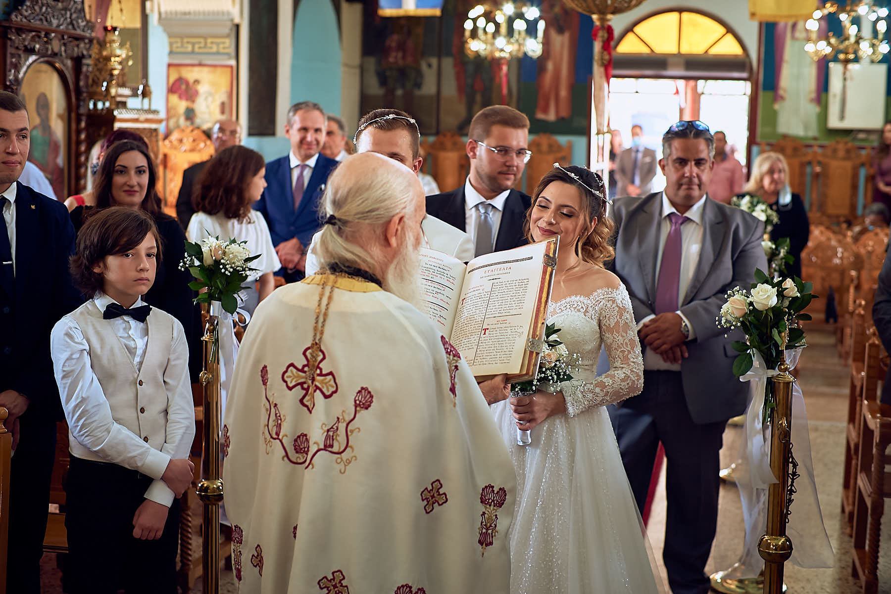 Priest reading the psalms, bride looking at peace, various people in the background