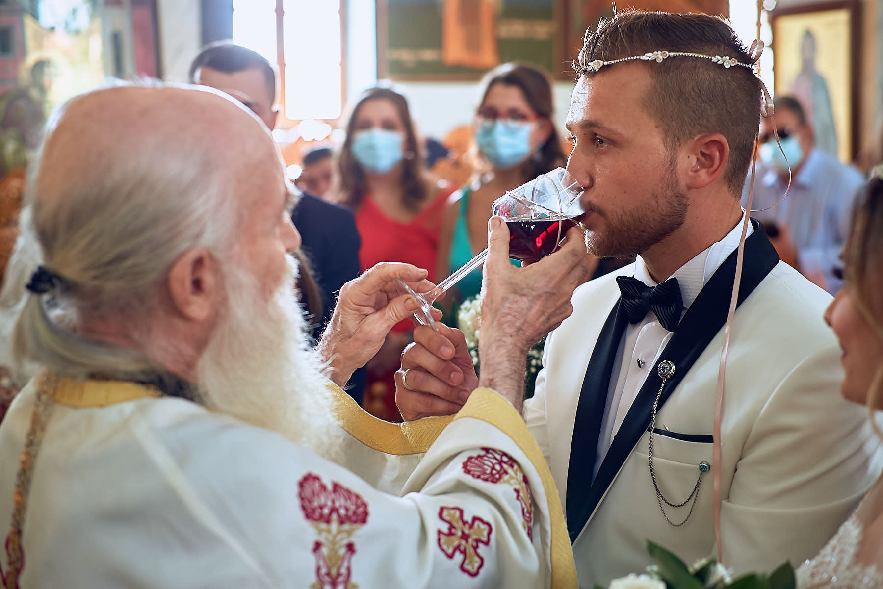 Groom drinking wine given by the priest