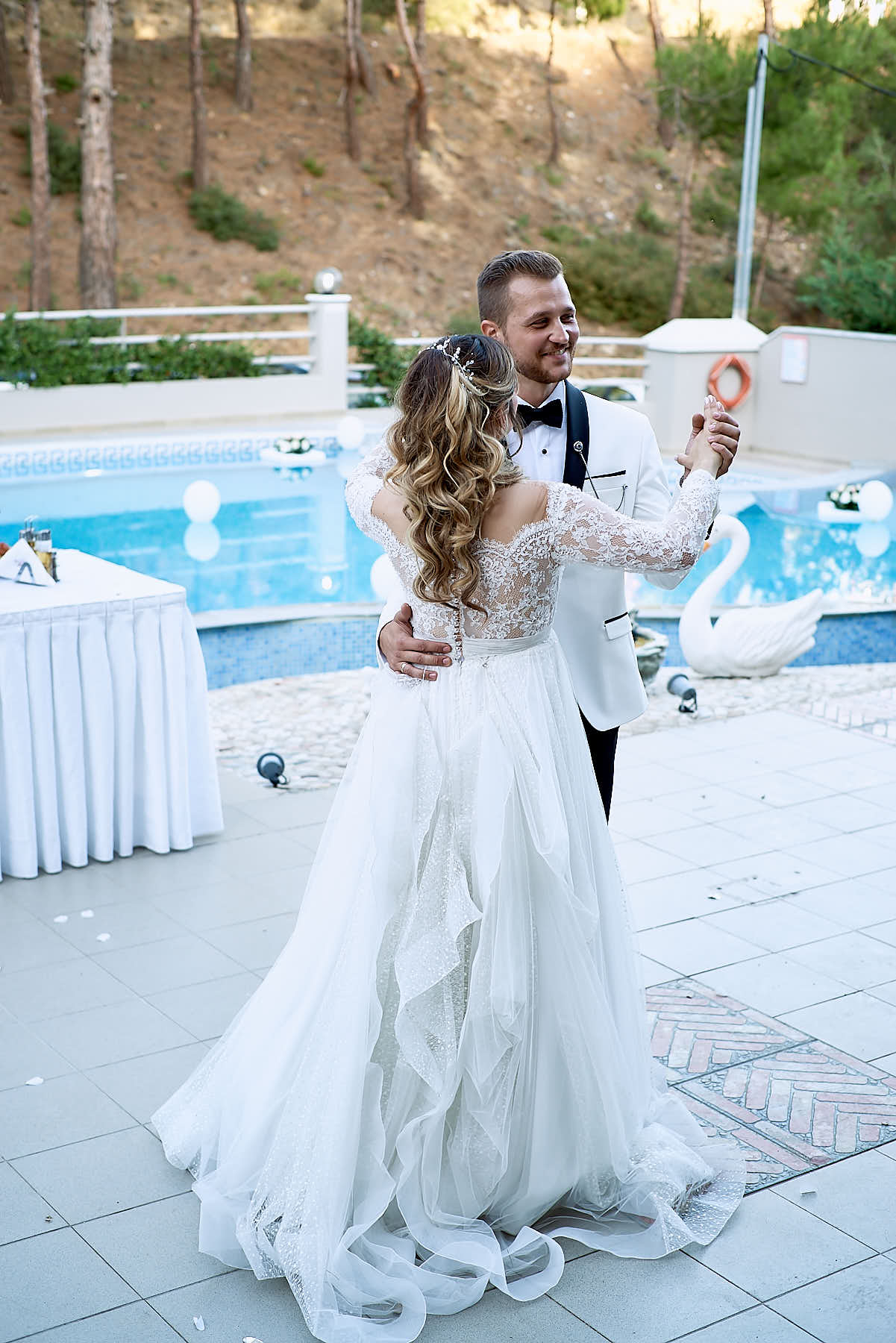 groom and bride dancing by the pool