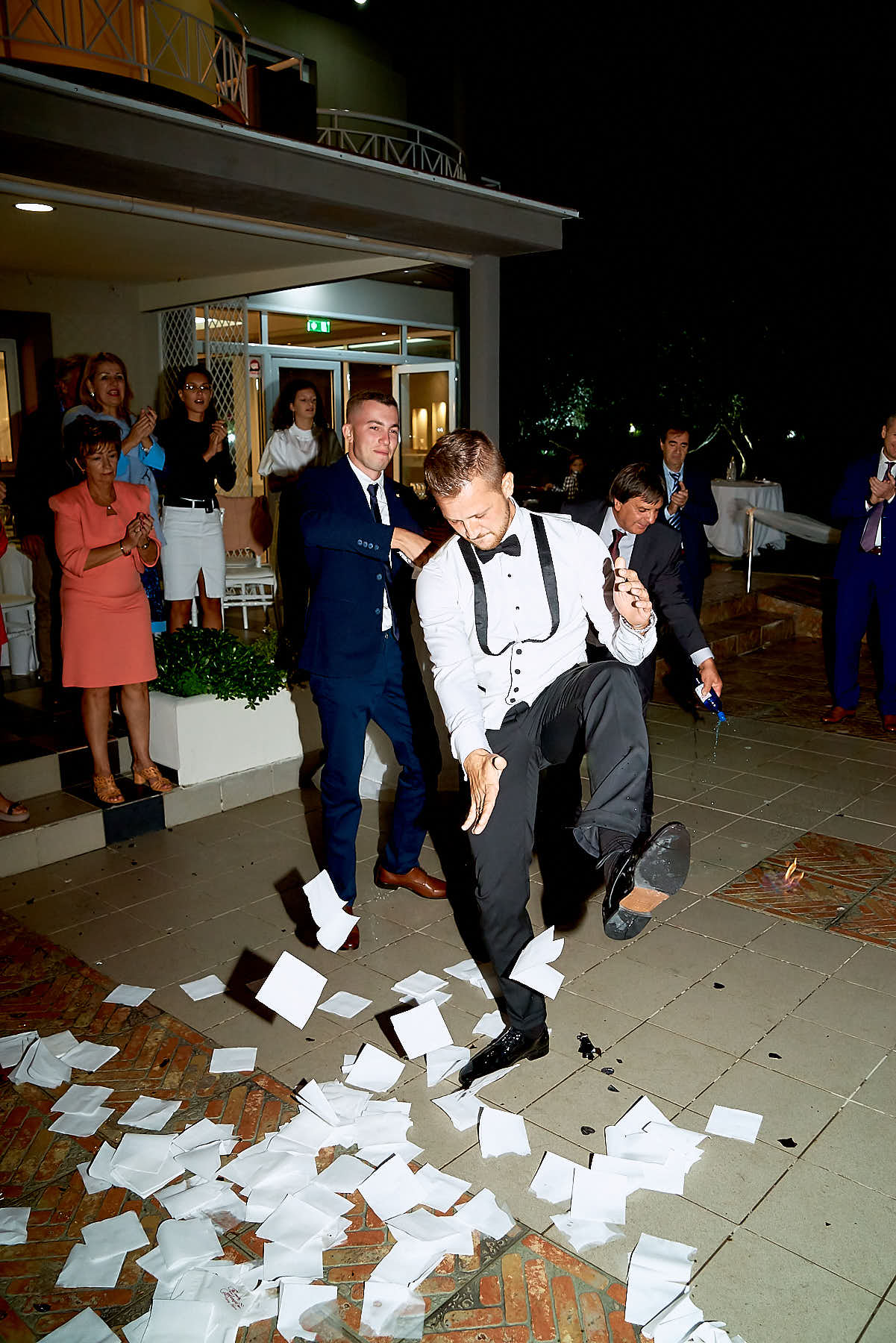 Groom dancing wildly and friends clapping