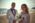 Groom holding bride's hand, bride looking at the horizon, at the beach