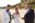 Groom, bride holding bouquet, relative holding brides hand by the beach