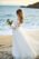 dreamy bride holding flowers looking at the sea