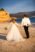 groom and bride holding hands while walking at the beach