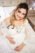 Pregnant bride touching her belly and smiling